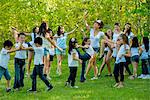 Large group of children dancing in park