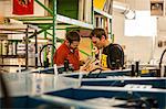 Workers checking color swatches in screen print workshop