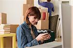 Woman looking at cellphone whilst moving house