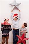 Children holding up Christmas decorations