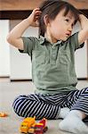 Boy sitting on floor with hands in hair