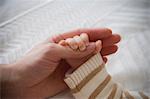 Baby boy holding mother's hand, close up