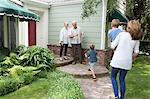 Senior couple greeting family at home