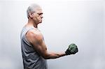 Senior man in sports clothing lifting broccoli