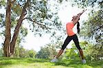 Young woman stretching in park