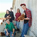 Farming family holding chickens, portrait