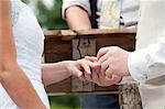 Close up of couple putting on rings at wedding ceremony