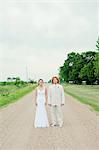 Portrait of couple on wedding day standing on dirt track