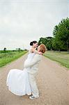 Couple on wedding day hugging on dirt track