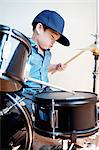 Male toddler playing drum kit