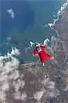 Woman in wingsuit flying above Honolulu, Hawaii