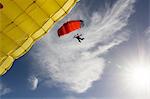 Female skydiver steering yellow parachute