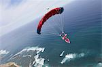 Skydiver with red parachute above Honolulu, Hawaii