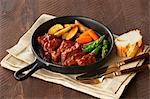 Still life of pan with meat, chips and vegetables