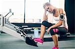 Young woman taking a break from exercising in gym