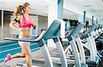 Young woman running on treadmill