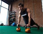 Male bodybuilder using kettlebells