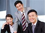 a team of asian business people looking at camera and  smiling.