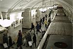 Blurred people on subway platform leaving the train.