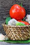 Ripe vegetables - tomatoes, cucumbers and garlic in a basket