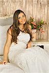 charming smiling bride sitting on a bed