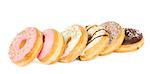 row of multicolored  donuts close up isolated on white background