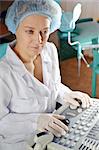 Female doctor in a white uniform working with scientific equipment.