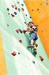 smiling elementary child climbing up the wall