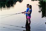 Boy and girl fishing on a lake