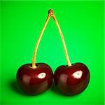 fresh red cherries with stem on green background