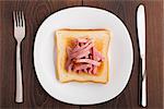 Toast with ham on a white plate