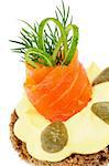 Delicious Snack with Smoked Salmon, Cheese Cream, Greens, Capers, Cucumber and Whole Grain Bread closeup on white