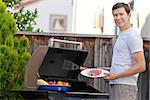 handsome young man ready for grilling meat and vegetables