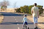 young man and his son at the balance bike walking and exercising