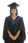 Happy Indian university student in graduation gown and cap. Portrait of mixed race Asian Indian and African American female model standing isolated on white background.