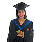 Happy Indian college student in graduation gown and cap. Portrait of mixed race Asian Indian and African American female model standing isolated on white background.