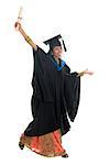 Full length happy Indian university student in graduation gown and cap holding diploma certificate jumping. Portrait of mixed race Asian Indian and African American female model standing isolated on white background.