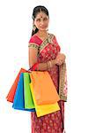 Beautiful young Indian woman in traditional sari dress having diwali shopping, standing isolated on white background.