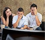 Disappointed Hispanic family sitting in front of television