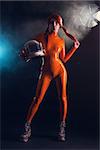 Sexy girl in orange latex catsuit holding helmet, sci-fi setting