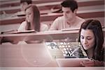 Concentrated student working on her futuristic tablet in lecture hall