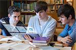 Serious students working on their digital tablet in university library