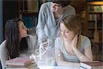 Smiling students working together with futuristic interface in university library