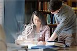 Concentrated college students analysing dna on digital interface in university library