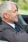 Relaxed businessman driving cabriolet on sunny day