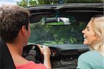 Rear view of smiling couple in cabriolet on a sunny day