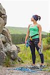 Attractive rock climber looking up at her challenge in the countryside