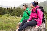 Couple sitting on a rock admiring the scenic view on a hiking trip