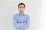 Serious man standing arms crossed and looking at camera on white background