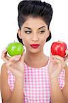 Pensive black hair model holding apples on white background